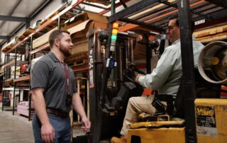 worker approaches forklift driver